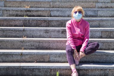woman with medical mask doing gymnastics in the city, new normal concept