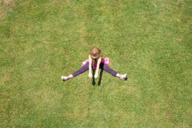 woman with medical mask doing gymnastics on the grass, new normal concept