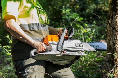 galicia, spain july 10, 2020: forest woman working in the bush with chainsaw