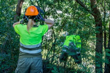 woman working in forest forest with protective helmet