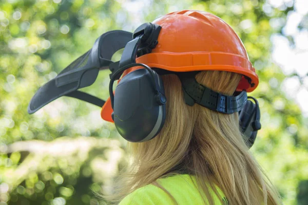 female forester worker with protective helmet in forest