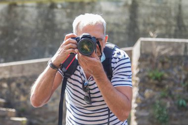Turist dijital kamerasıyla fotoğraf çekiyor.
