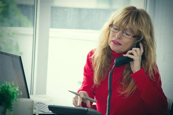 在办公室或家里用电话和计算机工作的女商人 — 图库照片