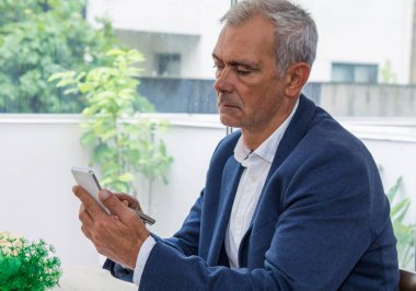 Ofisinde cep telefonu olan bir işadamı