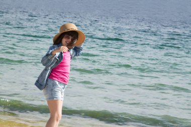 Kız sahilde yürüyor.