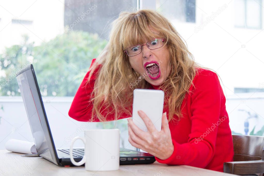 stressed woman in office yelling at mobile phone
