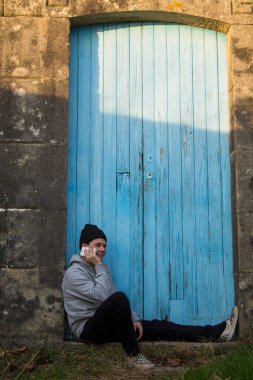 Akıllı telefon ya da cep telefonu kullanan gülümseyen adam