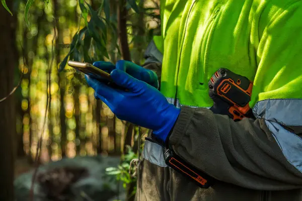 Miljö Eller Skogsarbetare Kontrollerar Sin Mobiltelefon — Stockfoto