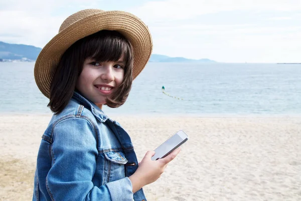 Meisje Hoed Spijkerjas Met Behulp Van Mobiele Telefoon Het Strand — Stockfoto