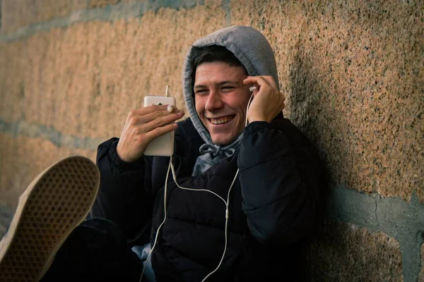 Молодий Чоловік Сидить Допомогою Мобільного Телефону Навушниками — стокове фото