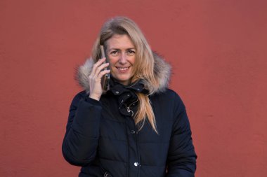 Cep telefonu kullanan gülümseyen kadın.