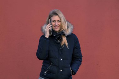 Cep telefonu kullanan gülümseyen kadın.