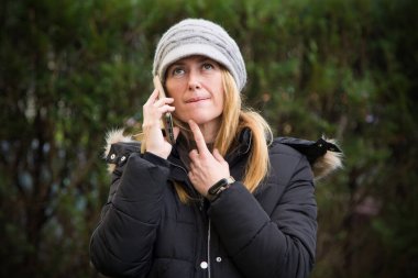 Cep telefonuyla konuşan düşünceli bir kadın.