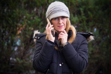 Yetişkin bir kadın cep telefonu kullanıyor.