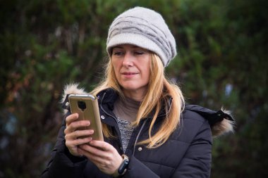 Yetişkin bir kadın cep telefonu kullanıyor.