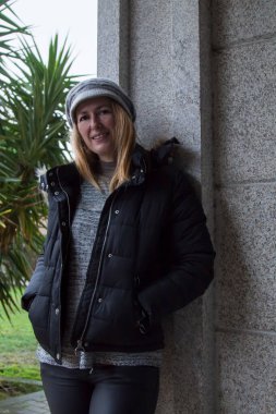 Şapkalı gülümseyen olgun bir kadının portresi.