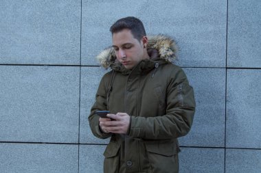 Sokakta cep telefonu olan genç bir adam.