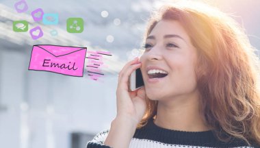 Genç bir kadın cep telefonuyla konuşuyor ve e-posta gönderiyor.