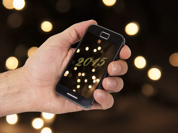 Mobiele en hand met Kerstmis achtergrond — Stockfoto