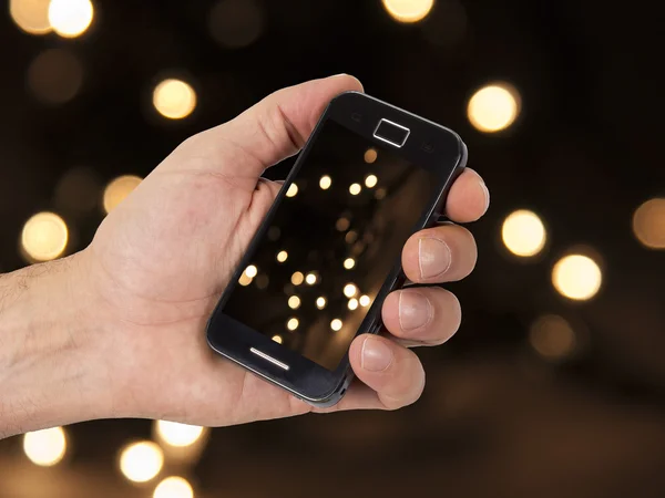 Cellulare e mano con sfondo di Natale — Foto Stock