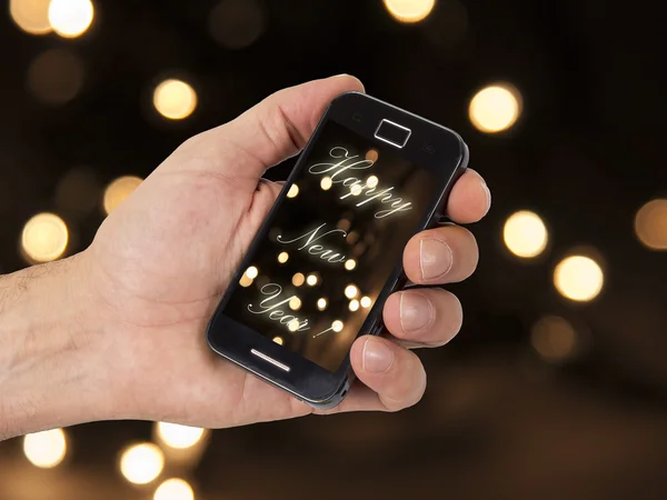 Mobiele en hand met Kerstmis achtergrond — Stockfoto