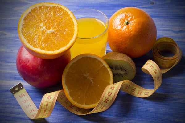 Апельсиновый сок с мерой для фруктов — стоковое фото