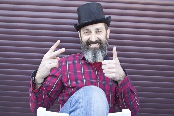 Bärtiger Mann sitzt und tut gut Symbol — Stockfoto