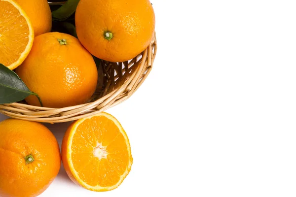 Korg med apelsiner på träskiva — Stockfoto