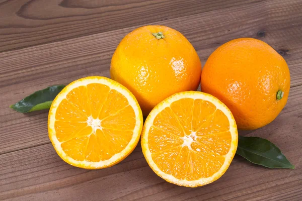 Cesta de naranjas sobre tabla de madera — Foto de Stock