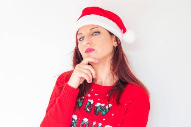 Noel şapkalı, eli çenesinde düşünceli bir genç kadın.