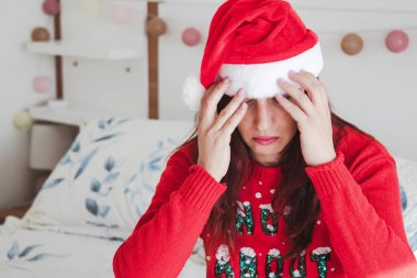 Üzgün ve bunalımlı genç bir kadın Noel 'de evde yalnız.