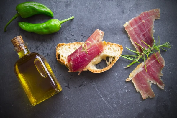 Prosciutto serrano con rosmarino verde e olio — Foto Stock