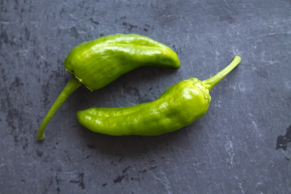 Green peppers on  black board — Stock Photo, Image