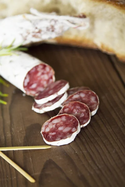 Salami and bread on wooden — Stock Photo, Image