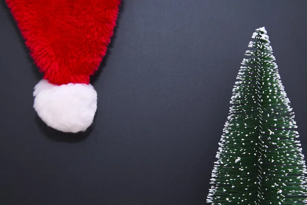 Slate and Christmas green tree with santa 's hat — стоковое фото