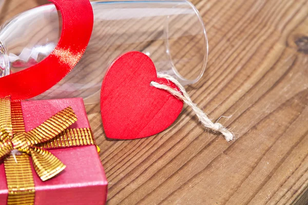 Glasses of champagne with red ribbon and gift box — Stock Photo, Image