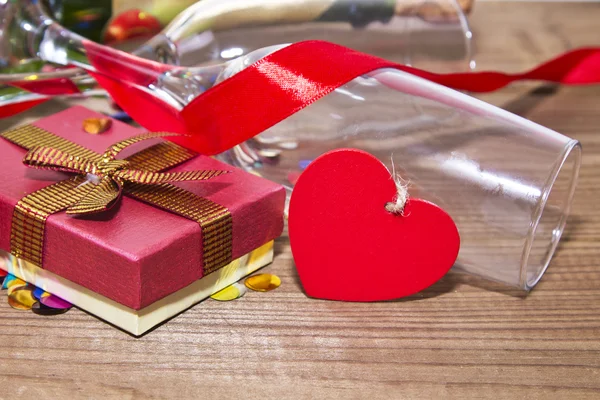 Glasses of champagne with red ribbon and gift box — Stock Photo, Image