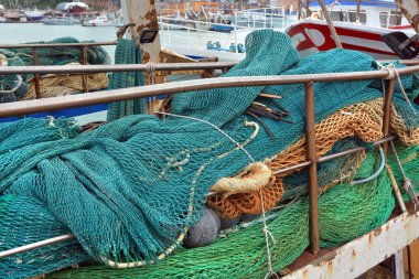 Güneşin altında bir balıkçı teknesinin üzerinde ağlar var.