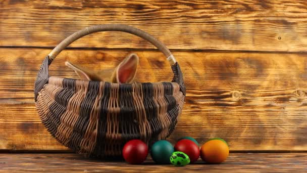 kis barna bolyhos aranyos nyúl ül egy fonott kosárban sokszínű válogatott húsvéti tojás