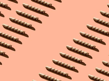 Krem rengi tüpler köşegen şeklinde ve arka planında keskin gölgeler ve fotokopi alanı var. Minimum tatlı yiyecek konsepti.