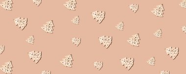 Yeni yıl kompozisyonu. Farklı boyutlarda ahşap Noel ağaçları ve kum renkli arka planda sert gölgeler. Düz yerde, üst tarafta. Yaratıcı asgari Noel sanatı