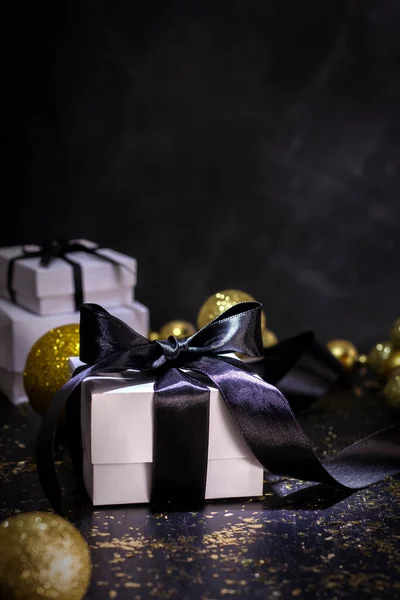 Weißes Geschenk Mit Schwarzer Schleife Auf Schwarzem Tisch Mit Goldenem — Stockfoto