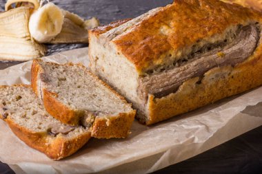 Geleneksel bir Amerikan yemeği, siyah beton arka planda glüten ve sütsüz muz ekmeğidir. Üst görünüm, alanı kopyala