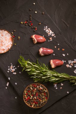 Kara tahtada taze çiğ tavuk kalbi, biber, tuz ve biberiye. Tavuk sakatatı