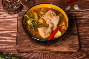 Ahşap bir masada haşlanmış patates ve tavuk etiyle kalın bir tabak.