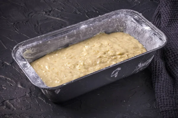 Het proces van het maken van een traditioneel Amerikaans gerecht van glutenvrij en zuivelvrij bananenbrood op een zwarte betonnen achtergrond. Bovenaanzicht, kopieer ruimte. — Stockfoto