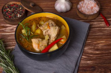 Ahşap bir masada haşlanmış patates ve tavuk etiyle kalın bir tabak.