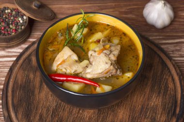 Ahşap bir masada haşlanmış patates ve tavuk etiyle kalın bir tabak.