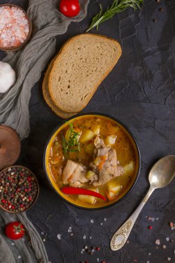 Koyu bir tabakta haşlanmış patates ve tavuk eti..