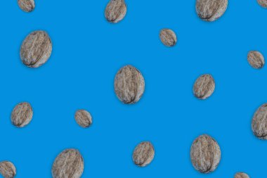 Yaratıcı gıda düzeni. Mavi arkaplanda ceviz. Üst görünüm kopyalama alanı. Yemek, sağlıklı yiyecekler, fındık, sağlıklı yağlar. Ceviz deseni. Organik sağlıklı vejetaryen atıştırmaları..